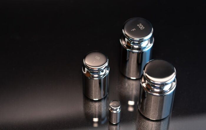 Close-up of weights used for scale calibration on a black background.